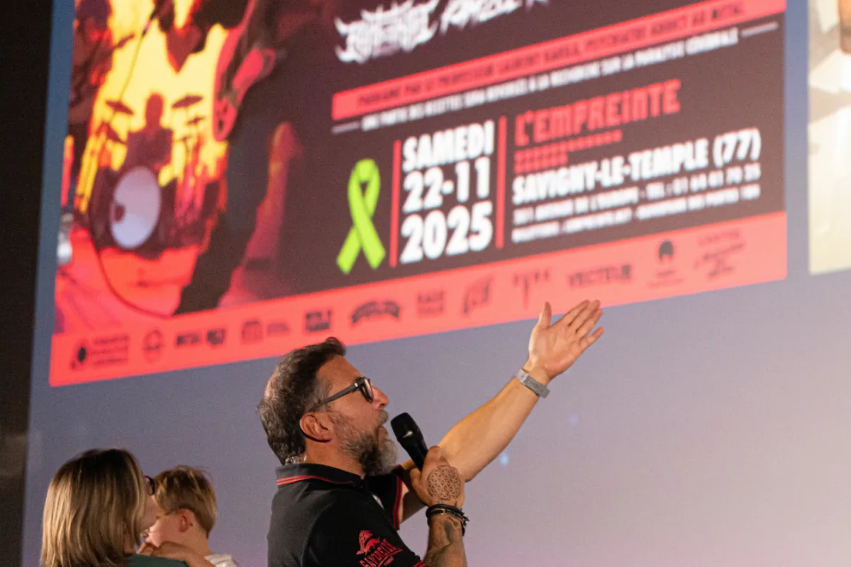 Président du festival présentant l’affiche du Charitable Metal Fest lors d’une conférence