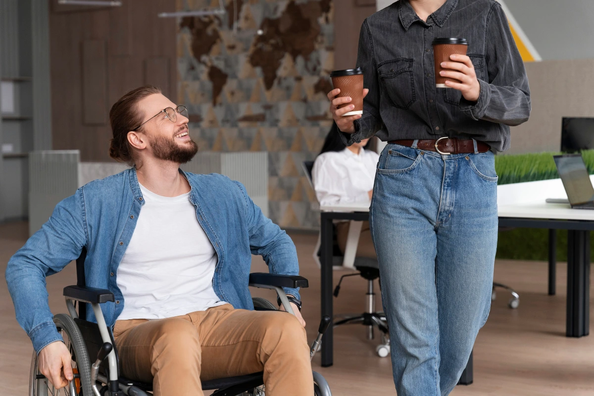 Personne en fauteuil roulant échangeant avec une collègue au bureau