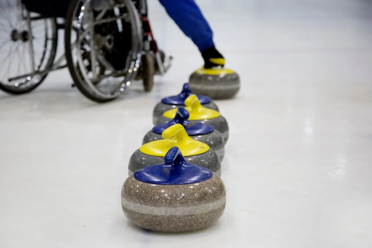 Athlète en fauteuil roulant jouant au curling lors des Jeux Paralympiques, illustration de l'innovation au service du handicap et de l'autonomie