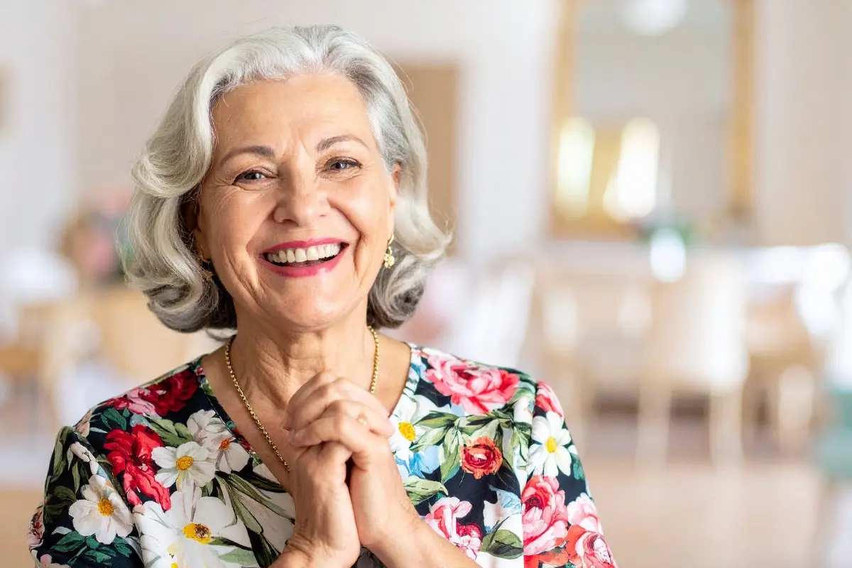 Femme âgée souriante à son domicile, représentant l'autonomie et le bien-vieillir grâce à l'aide à domicile dans le Calvados
