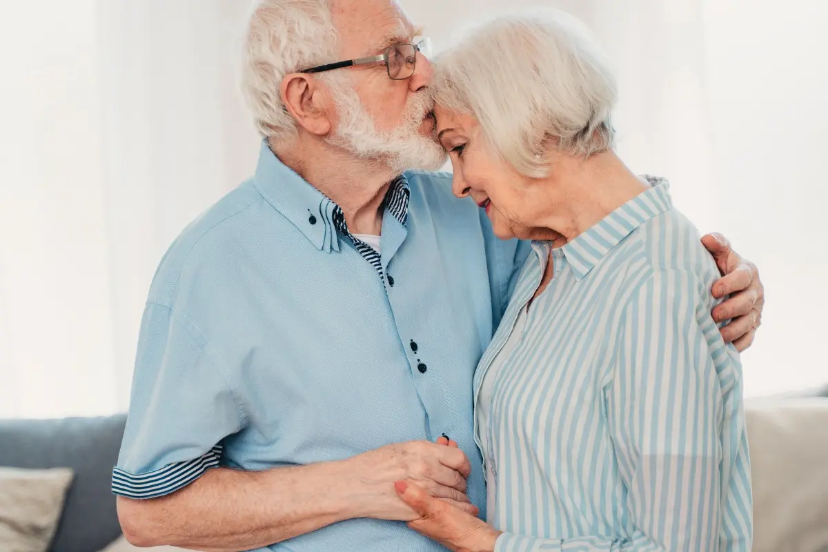 Aide domicile Alzheimer : Couple de personnes âgées s'étreignant, illustrant la proximité, le lien affectif et le soutien dans l'accompagnement de la maladie d'Alzheimer à domicile