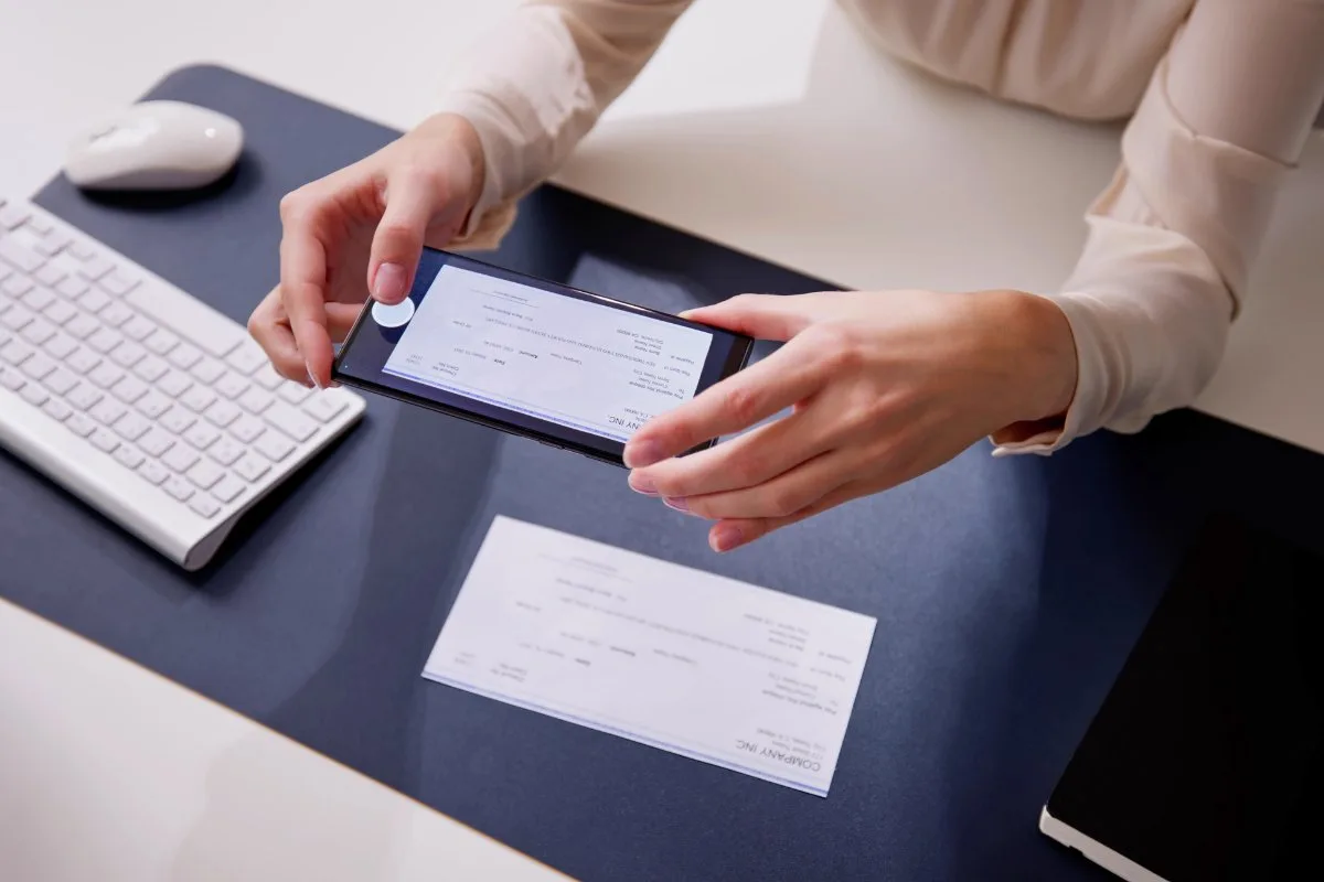 Personne scannant un chèque CESU avec son smartphone pour régler un service à domicile